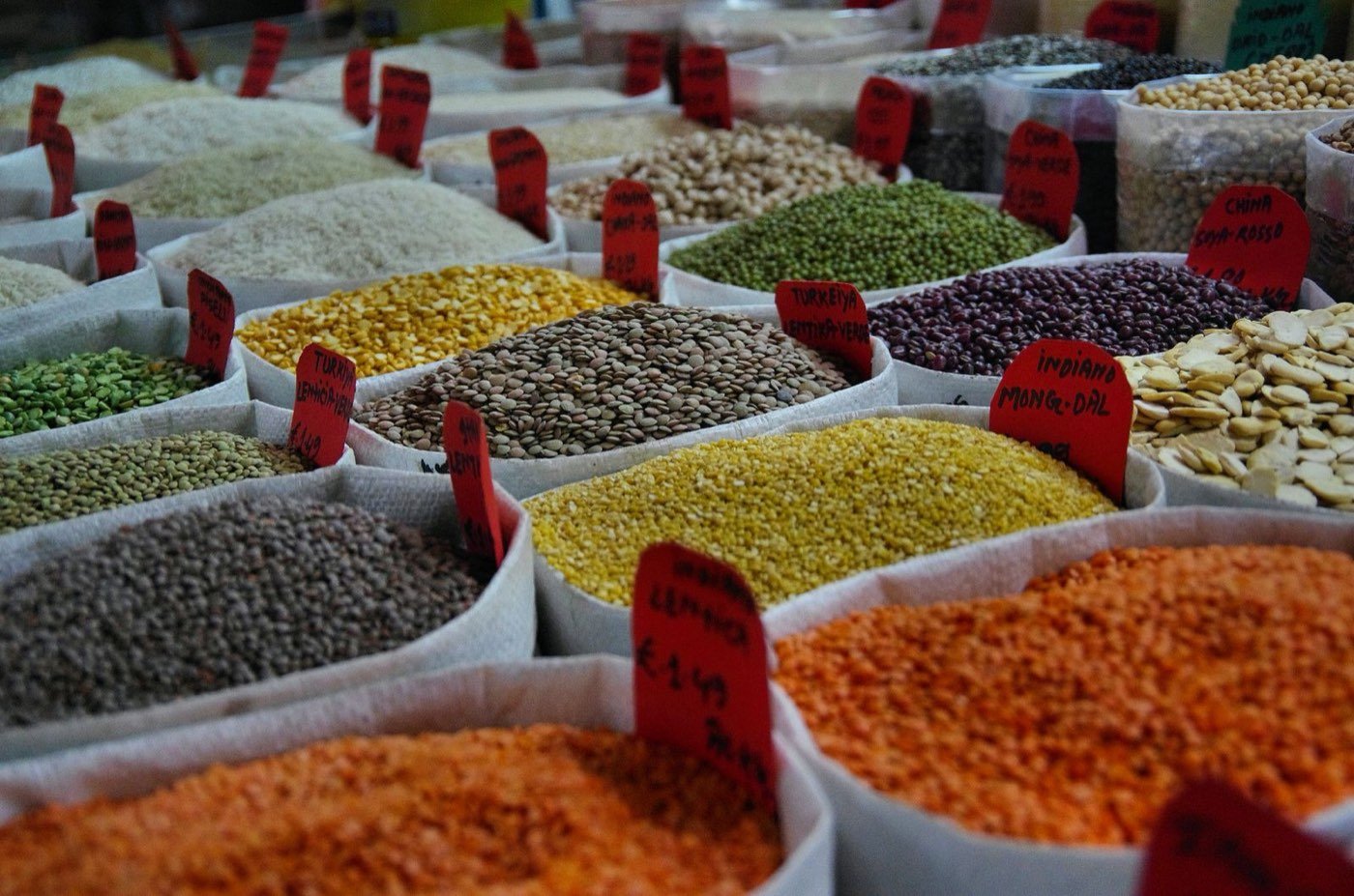 Sacks of colorful lentils, grains, and beans at an international market